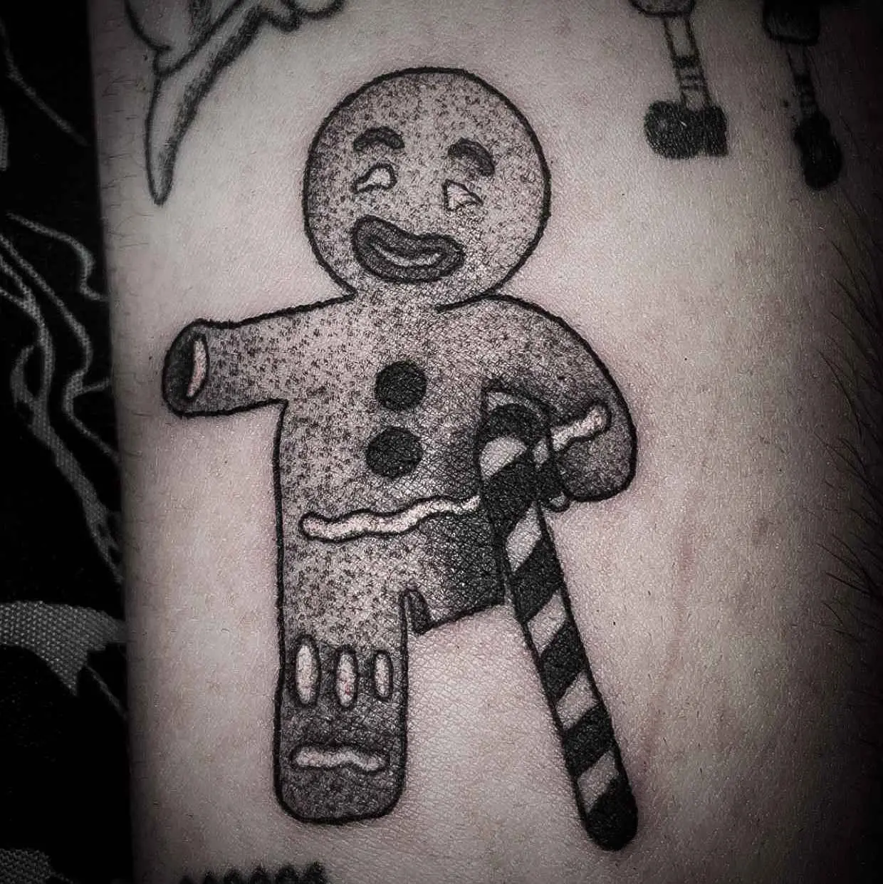 Gingerbread man with candy cane cane tattoo. 